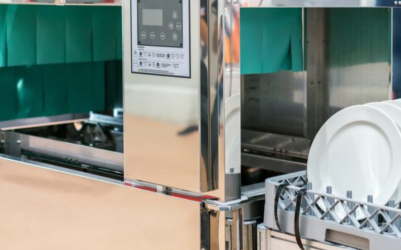 close up white dish on basket in automatic dishwasher machine for industrial